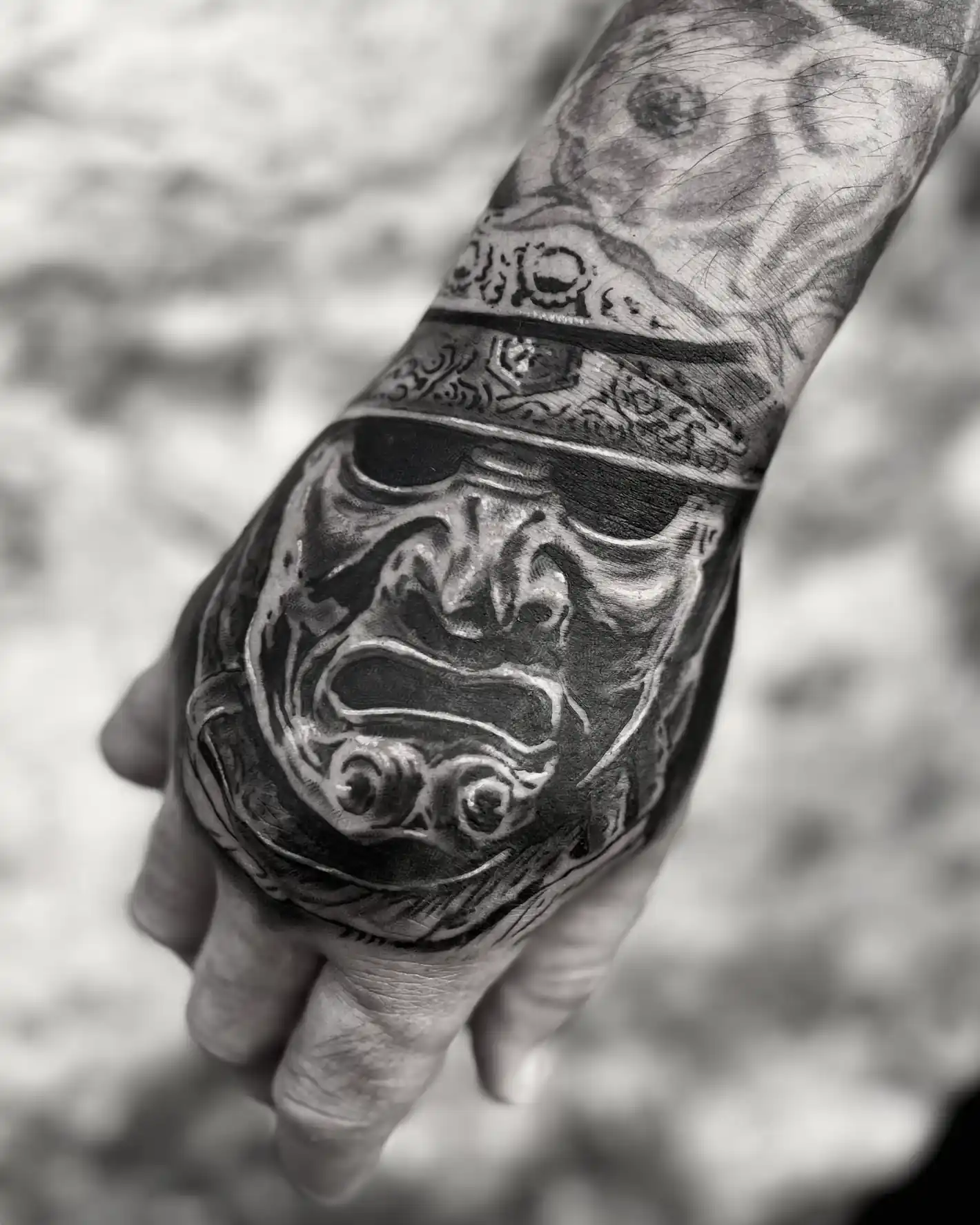 Tatouage noir et gris d'un masque de samouraï sur la main — Jeremy Lorenzato, Art du Noir Nice