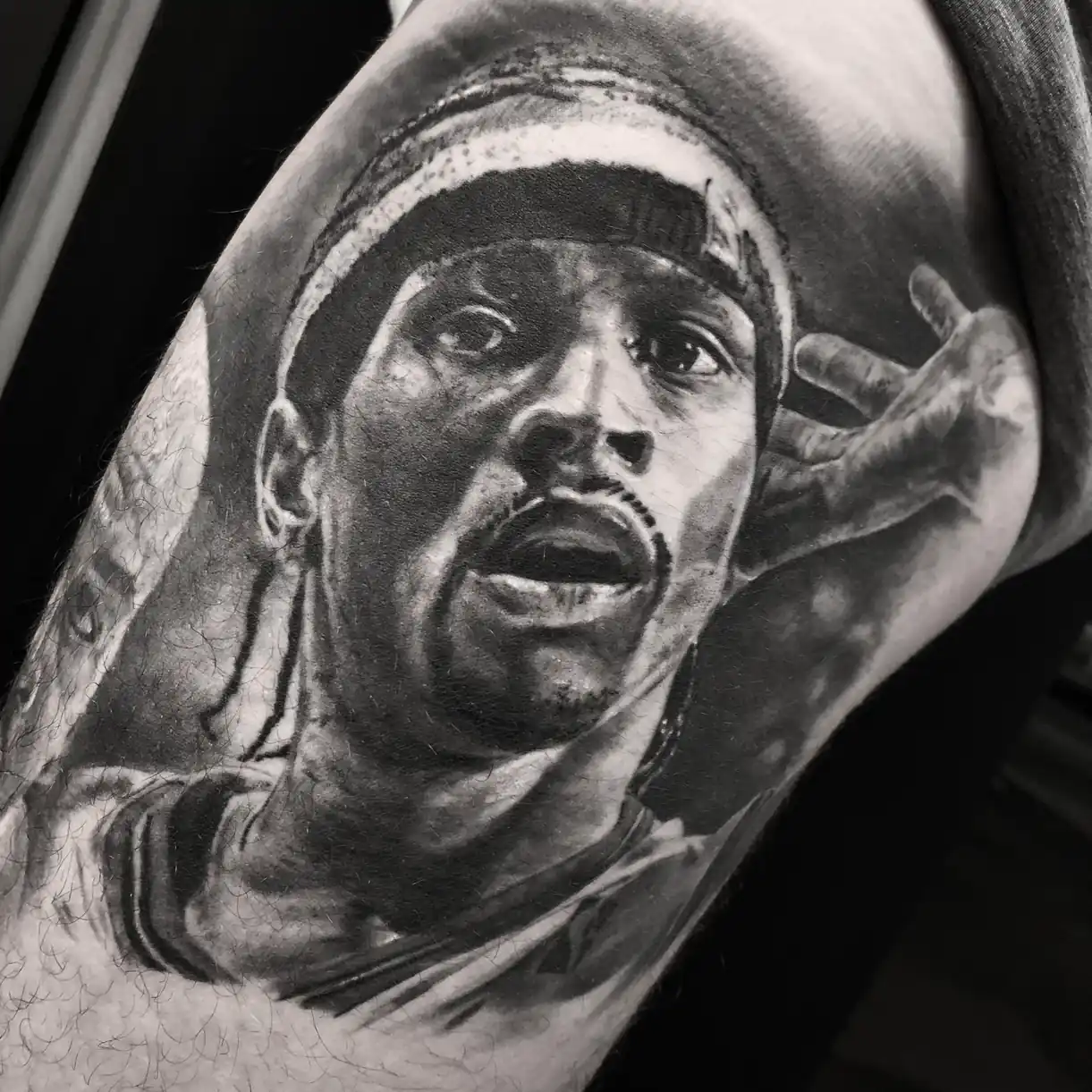 Tatouage réaliste noir et gris du portrait d’un sportif sur le bras — Art du Noir, Nice