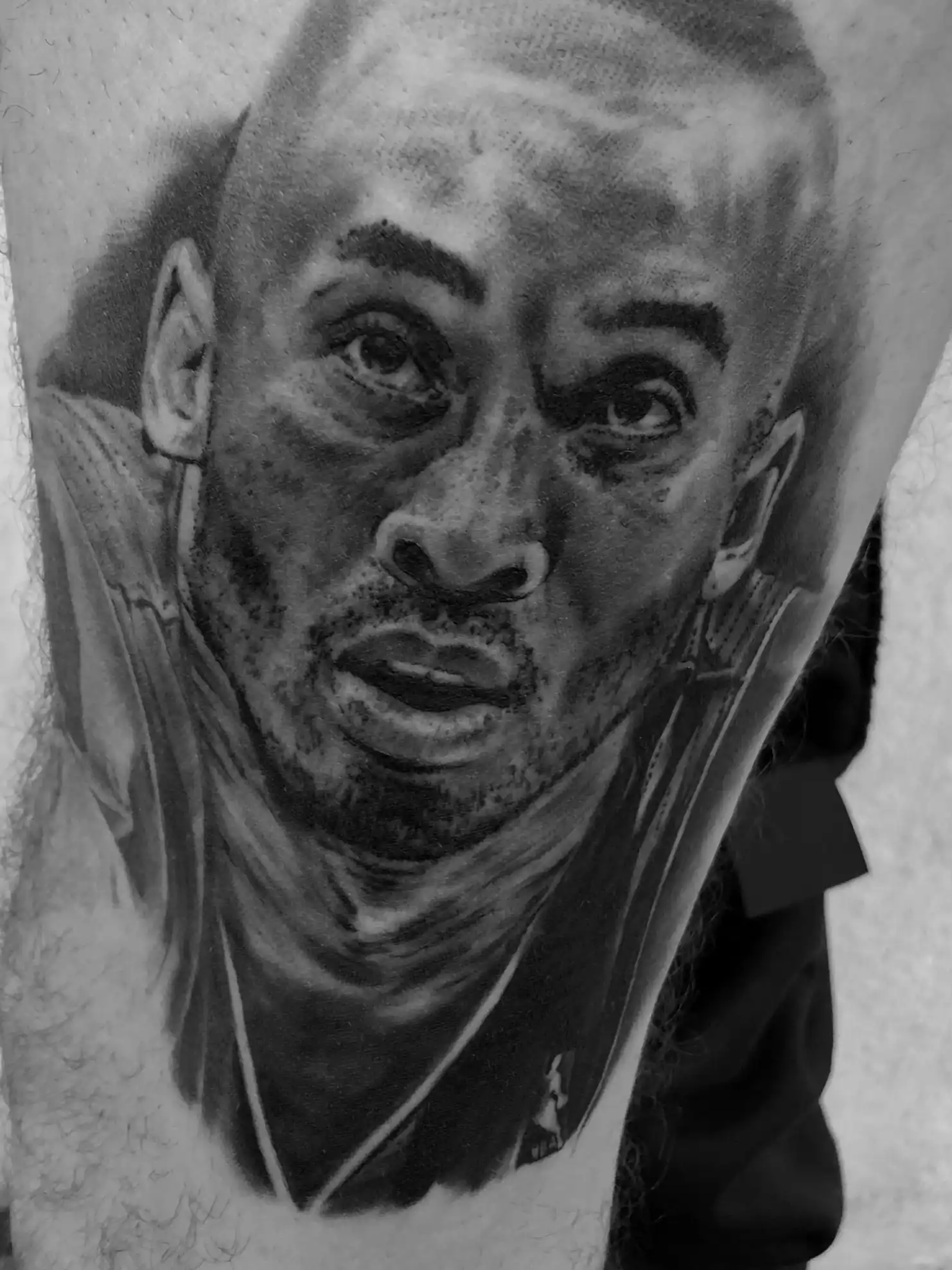 Tatouage réaliste noir et gris d'un portrait de sportif sur le bras — Jeremy Lorenzato, Art du Noir Nice