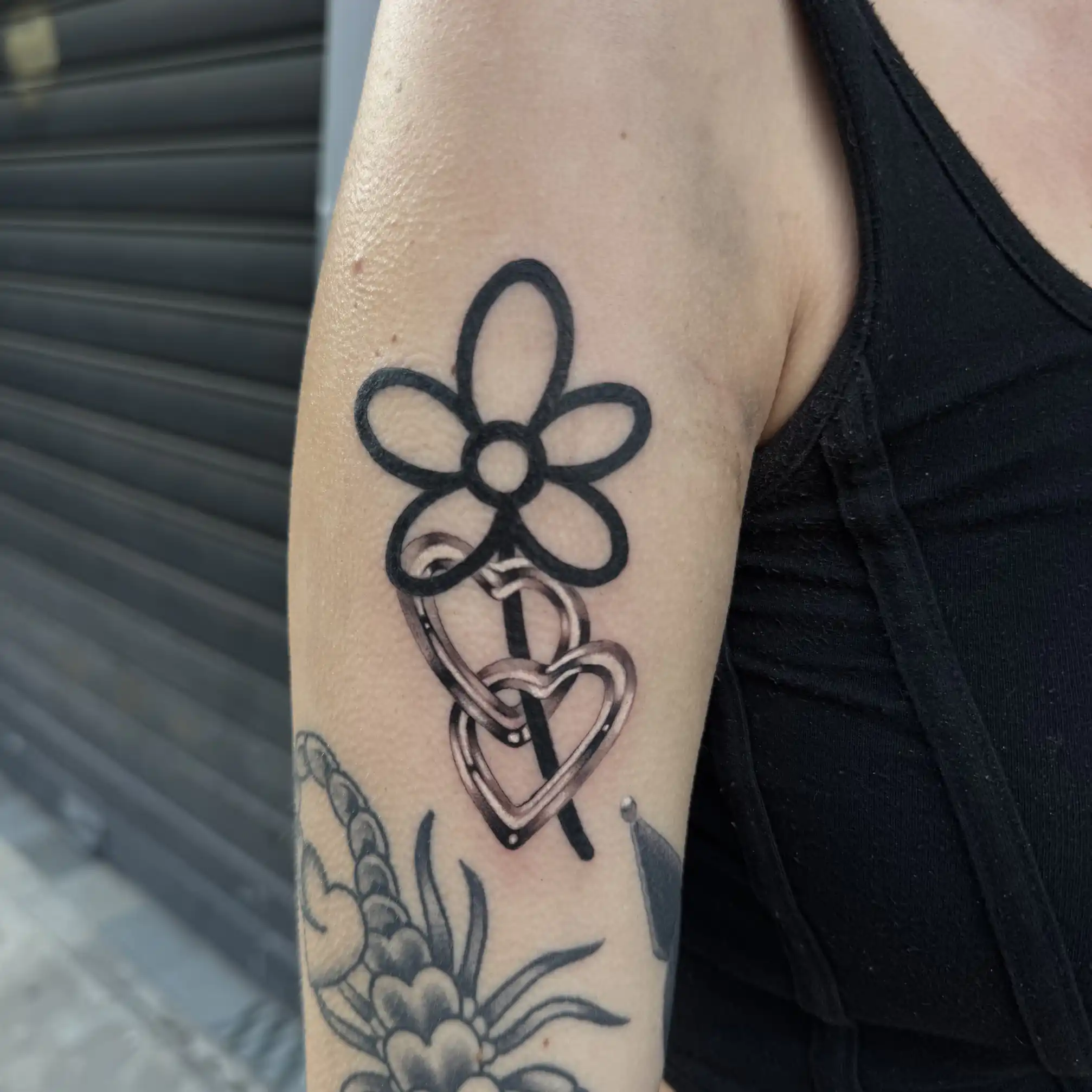 Tatouage bold line d'une fleur et d'un cœur sur le bras — Poutz, Art du Noir Nice