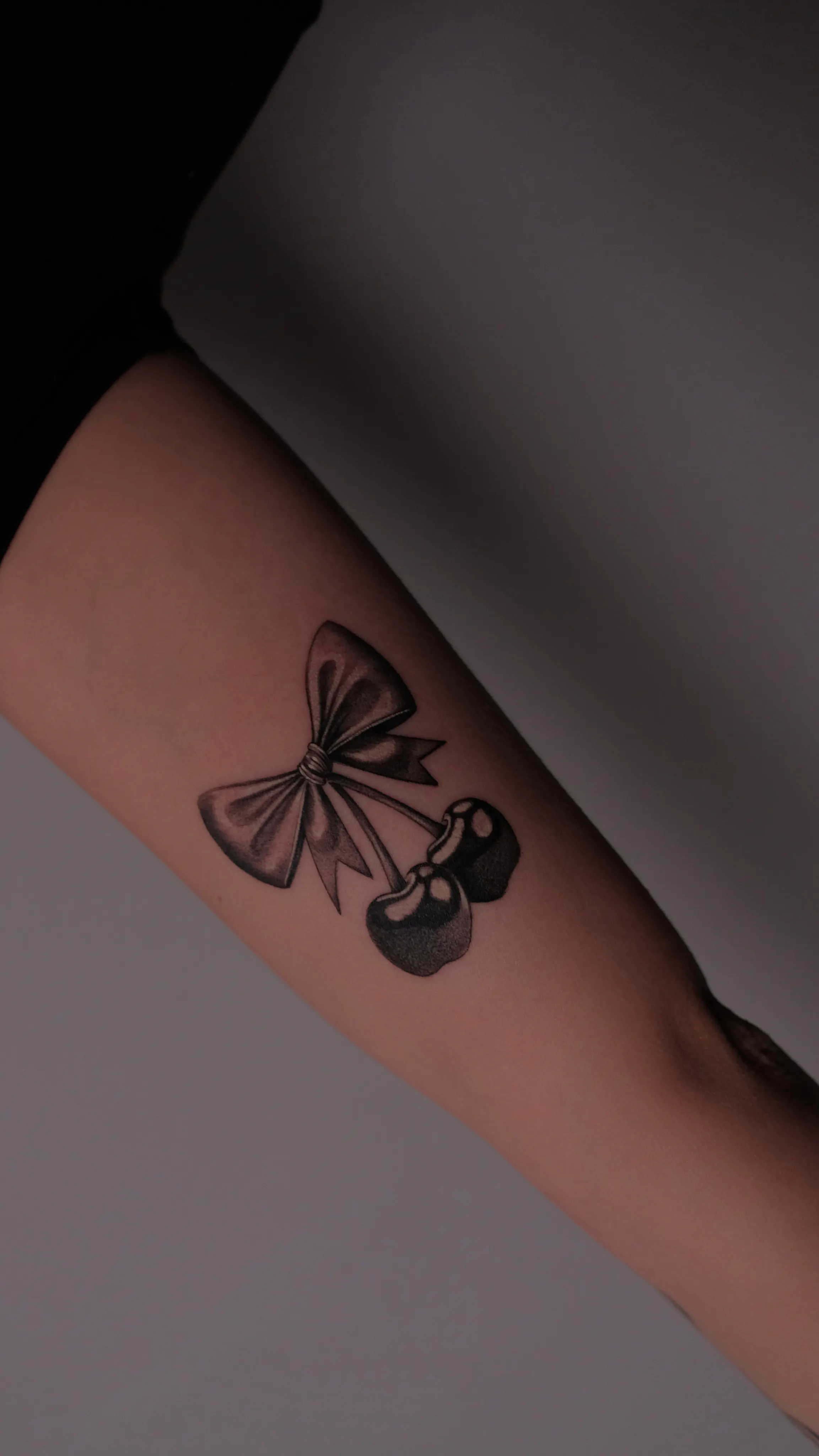 Tatouage micro réalisme de cerises sur le bras — Art du Noir, Nice