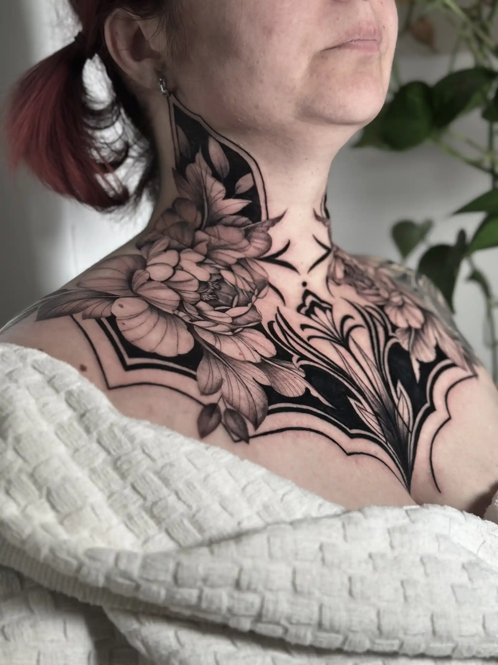 Tatouage floral noir et gris sur le cou et la clavicule — Art du Noir, Nice