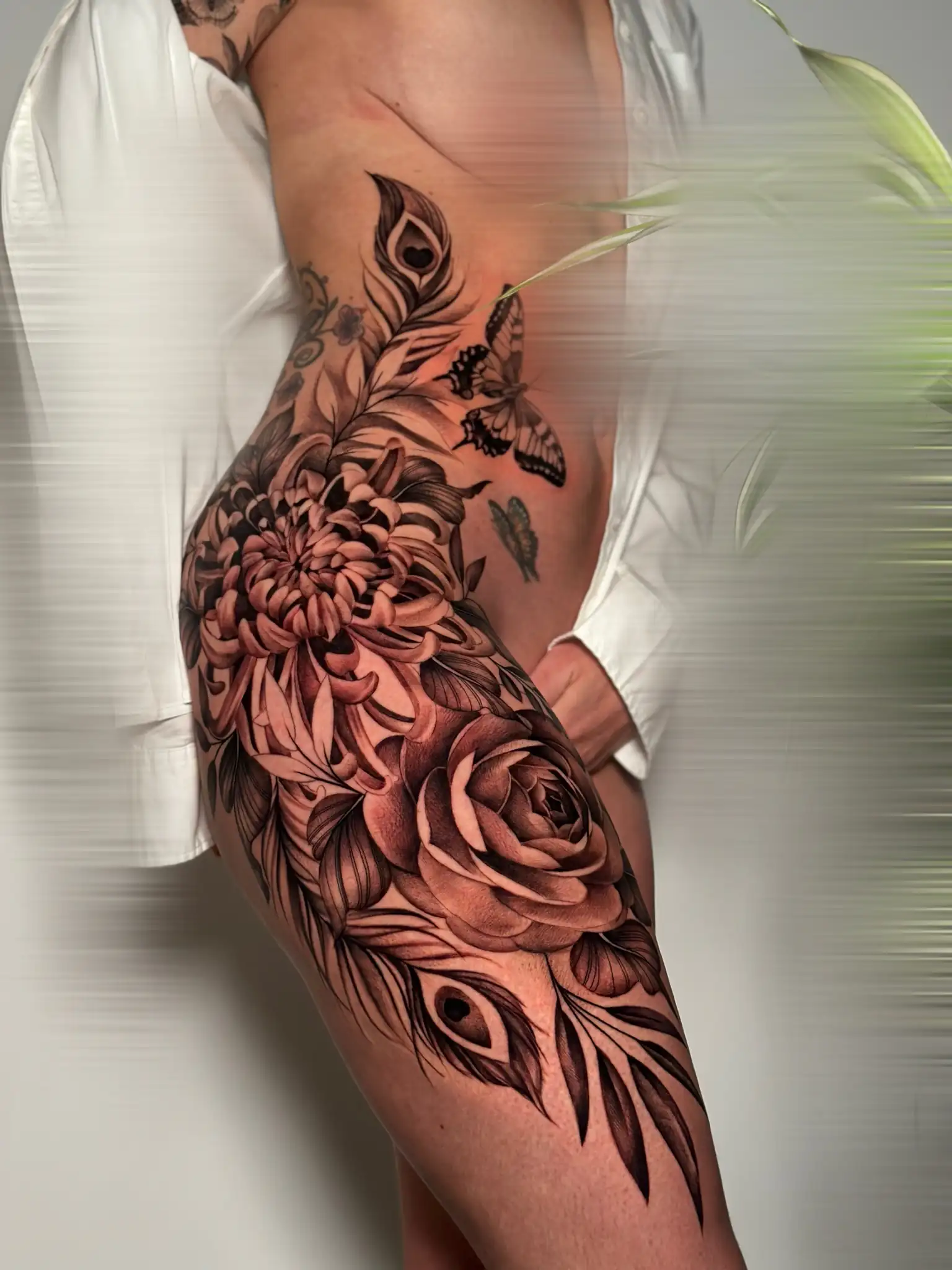 Composition florale noir et gris sur la hanche et la cuisse — Sainte Elo, Art du Noir Nice