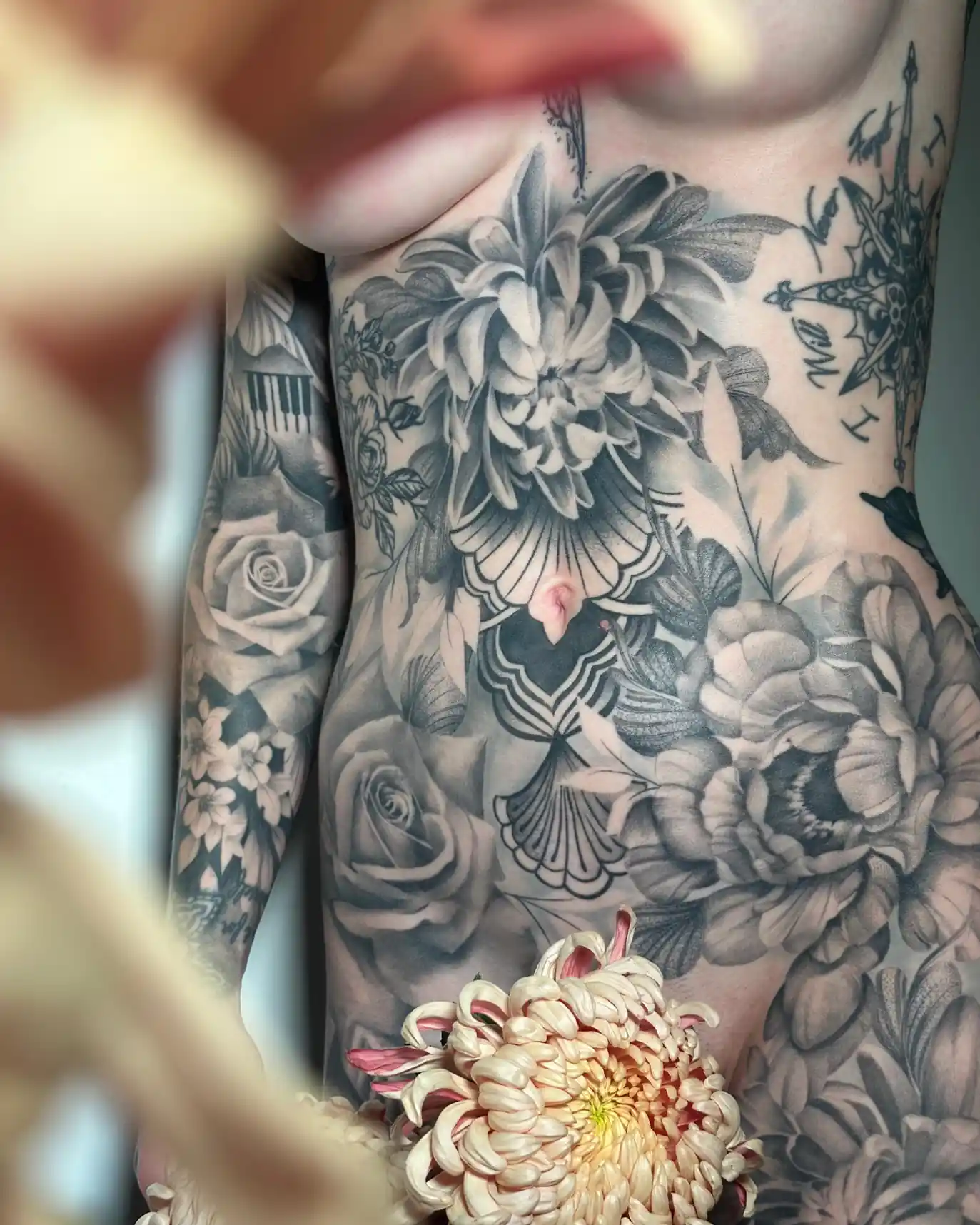 Tatouage floral noir et gris de pivoines sur le torse — Art du Noir, Nice